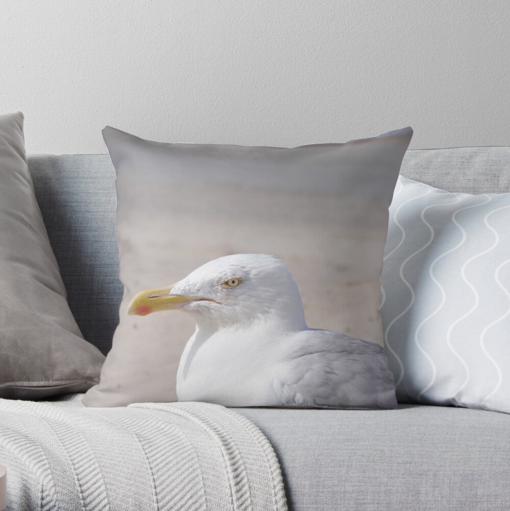 Product image for throw pillow: Seagull looking sideways on a beach.